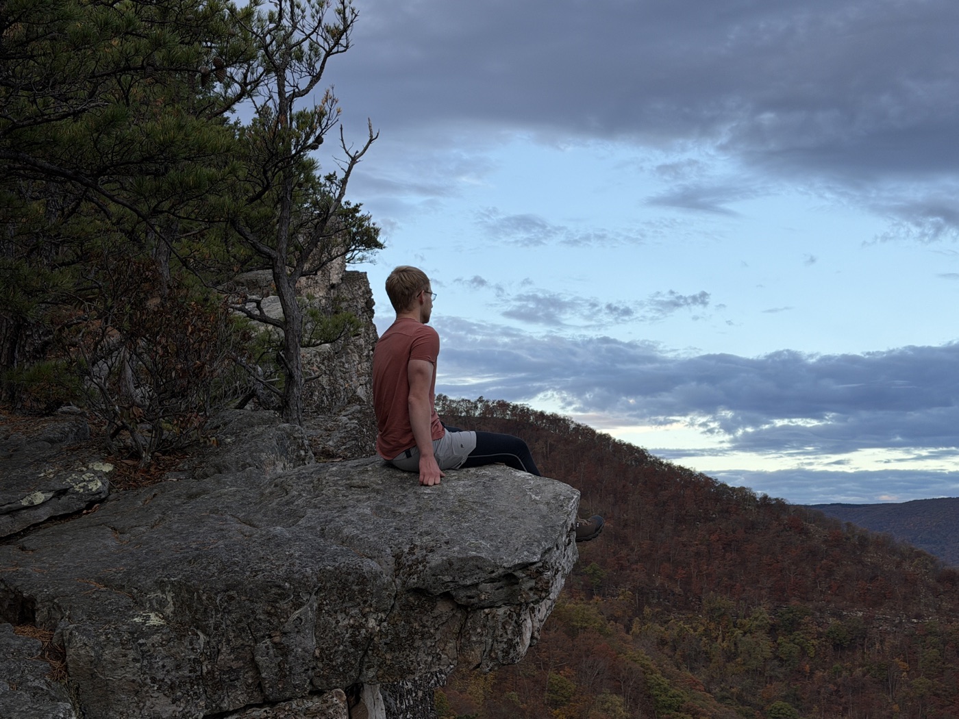Caleb sitting on a rock in the mountains