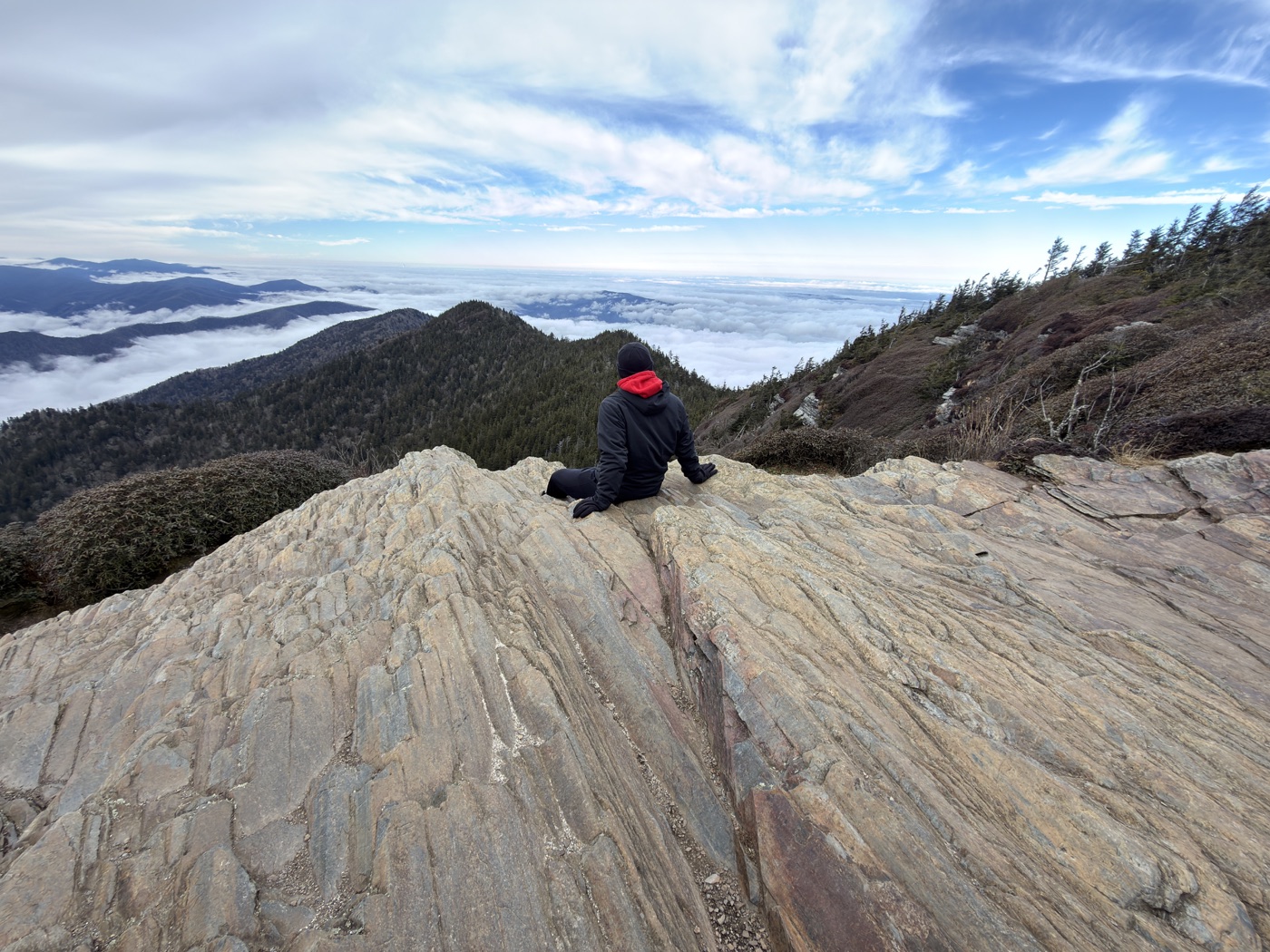 Caleb sitting on a rock in the mountains